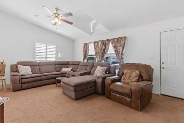 a living room with furniture ceiling fan and a window