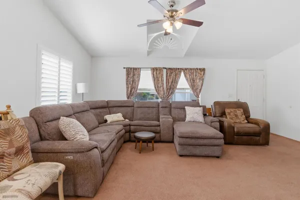 a living room with furniture ceiling fan and a window