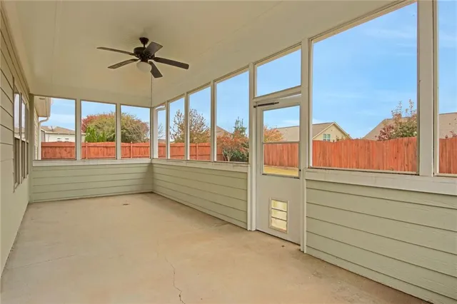 a view of an empty room window ceiling fan and windows