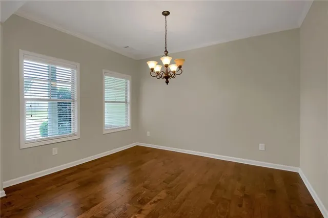 a view of a room with wooden floor and chandelier