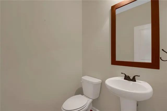 a bathroom with a sink mirror and toilet