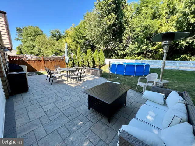a view of a patio with couches chairs and a fire pit and an umbrella