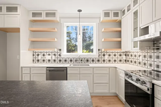 a kitchen with a stove a sink a center island and a wooden floor