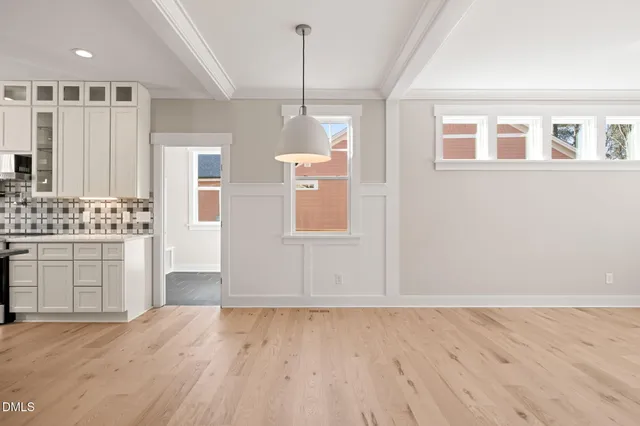 a large white kitchen with kitchen island a sink appliances and a counter top space