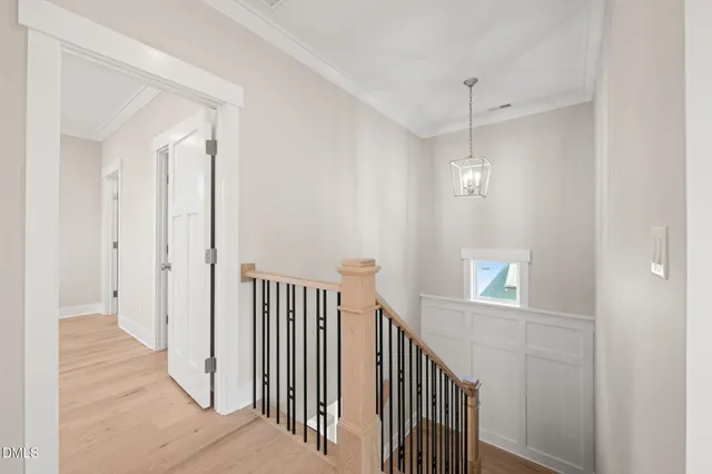 a view of a livingroom with a fireplace a chandelier and wooden floor