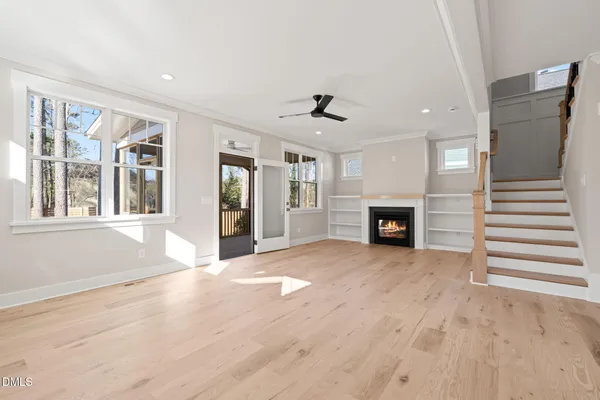 a view of a livingroom with a fireplace a chandelier and wooden floor