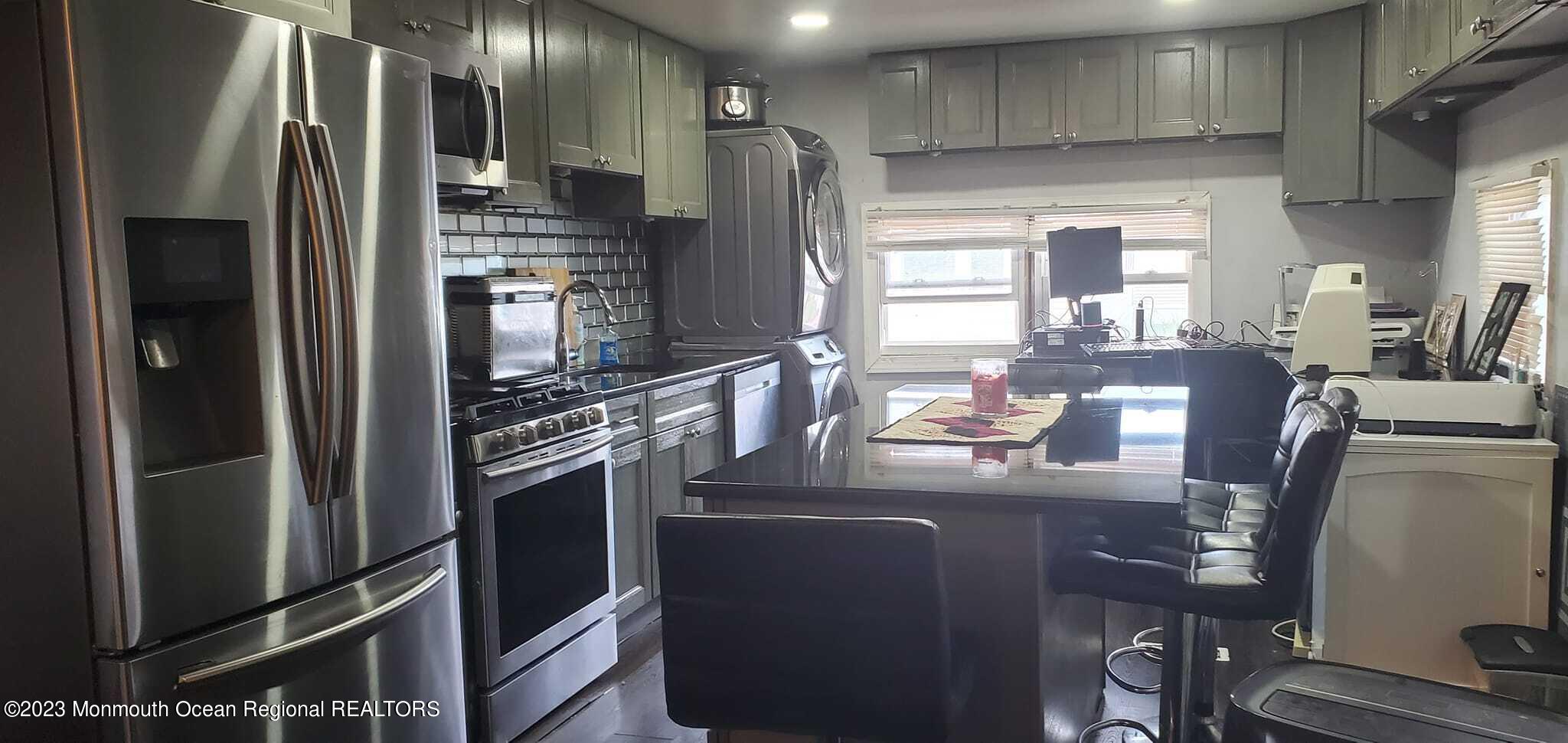 a kitchen with refrigerator and chairs