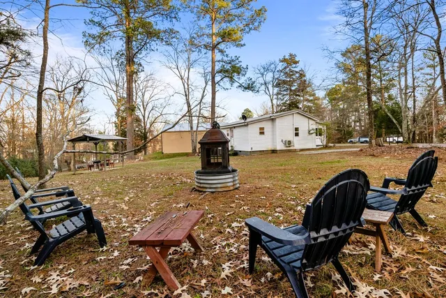 a view of house with a yard in the background