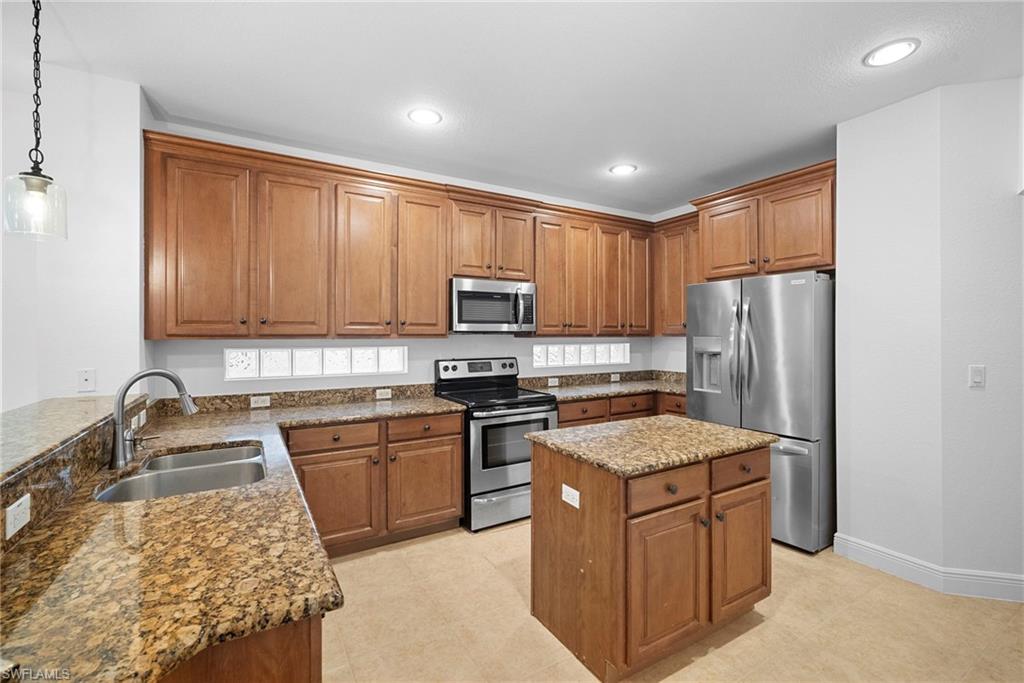 8286 Sumner Avenue, Unit 1 Fort Myers, FL 33908 - Photo 4 of 13 Kitchen with brown cabinetry, stainless steel appliances, dark stone countertops, pendant lighting, and recessed lighting
