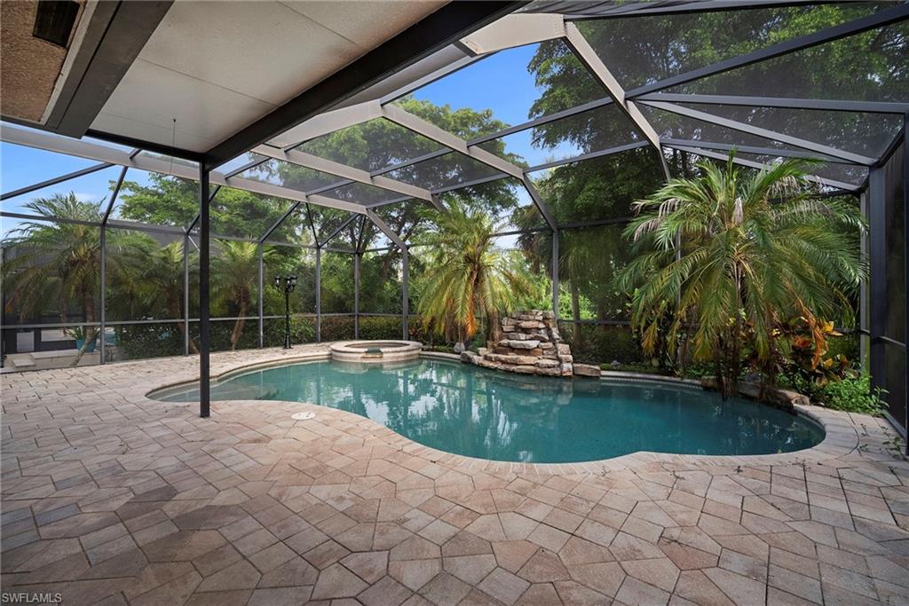 8286 Sumner Avenue, Unit 1 Fort Myers, FL 33908 - Photo 7 of 13 View of pool featuring glass enclosure, a pool with connected hot tub, a sunroom, and a patio area