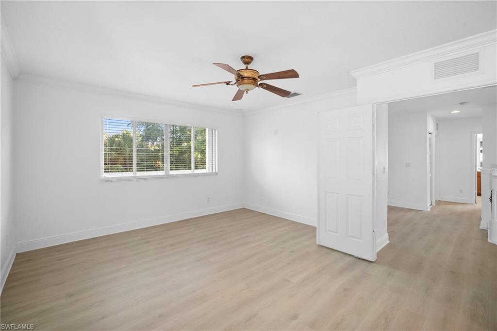 8286 Sumner Avenue, Unit 1 Fort Myers, FL 33908 - Photo 8 of 13 Primary bedroom room with light wood-style floors, ornamental molding, and a ceiling fan