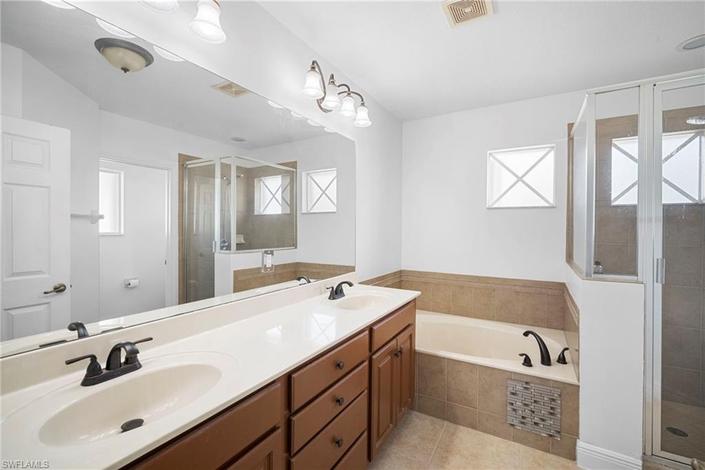 8286 Sumner Avenue, Unit 1 Fort Myers, FL 33908 - Photo 9 of 13 Full bath featuring plenty of natural light, a stall shower, a bath, and double vanity