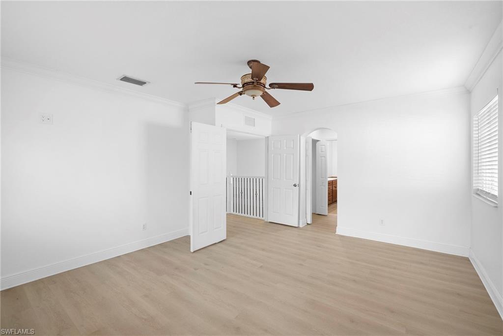 8286 Sumner Avenue, Unit 1 Fort Myers, FL 33908 - Photo 10 of 13 Bedroom featuring crown molding, light wood-type flooring, arched walkways, and ceiling fan