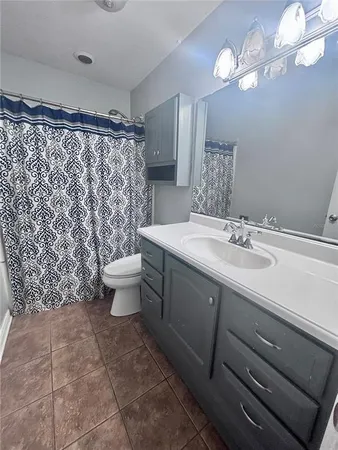 a bathroom with a sink vanity mirror and toilet