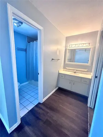 a view of an empty room with wooden floor and stairs