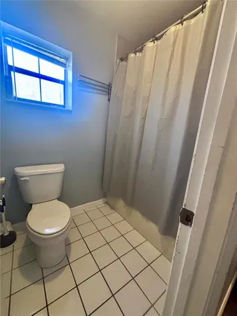 a bathroom with a toilet and a shower curtain