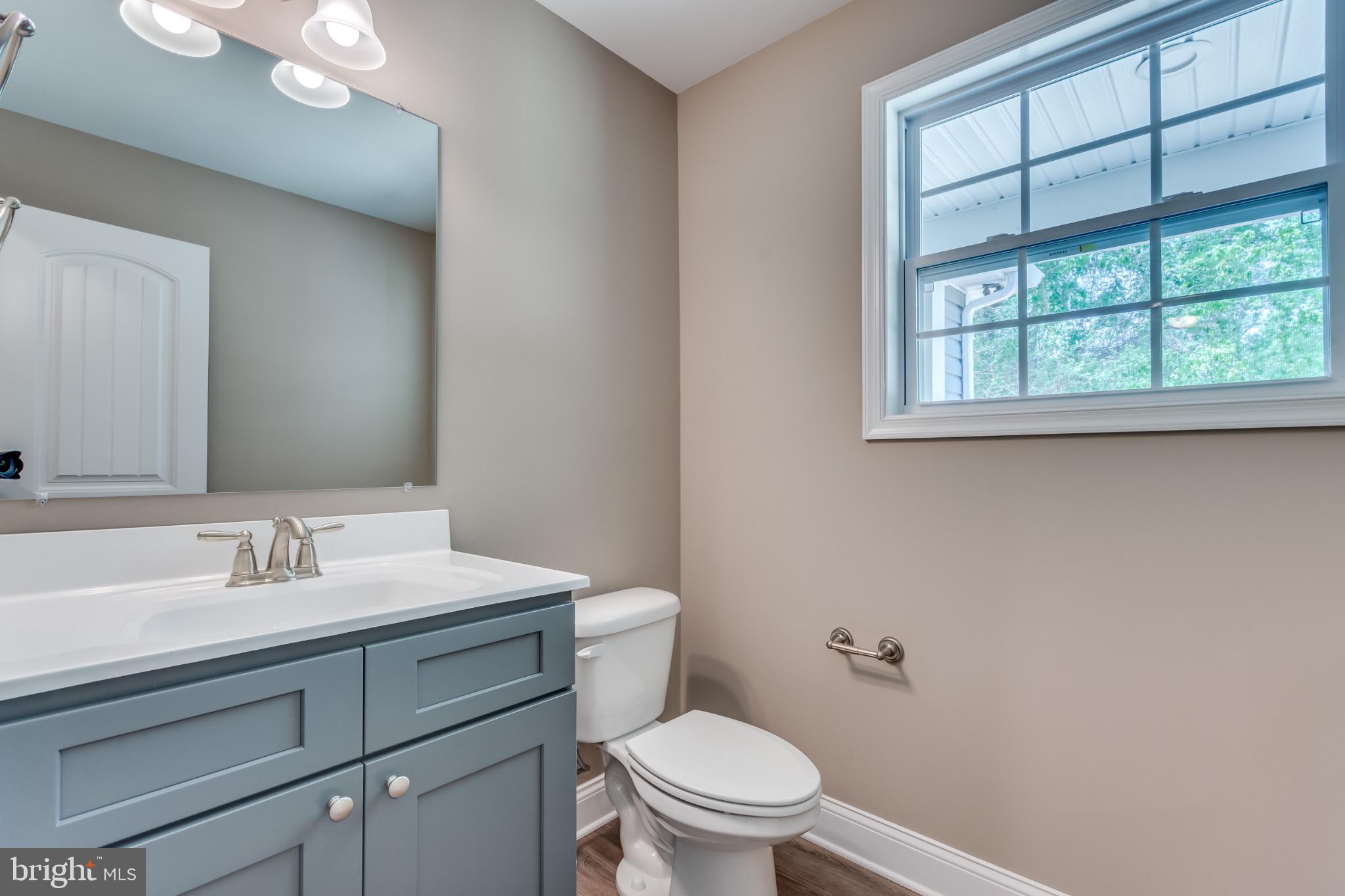 1 Libby's Ridge Road Berkeley Springs, WV 25411 - Photo 14 of 31 a bathroom with a toilet a sink a vanity and windows