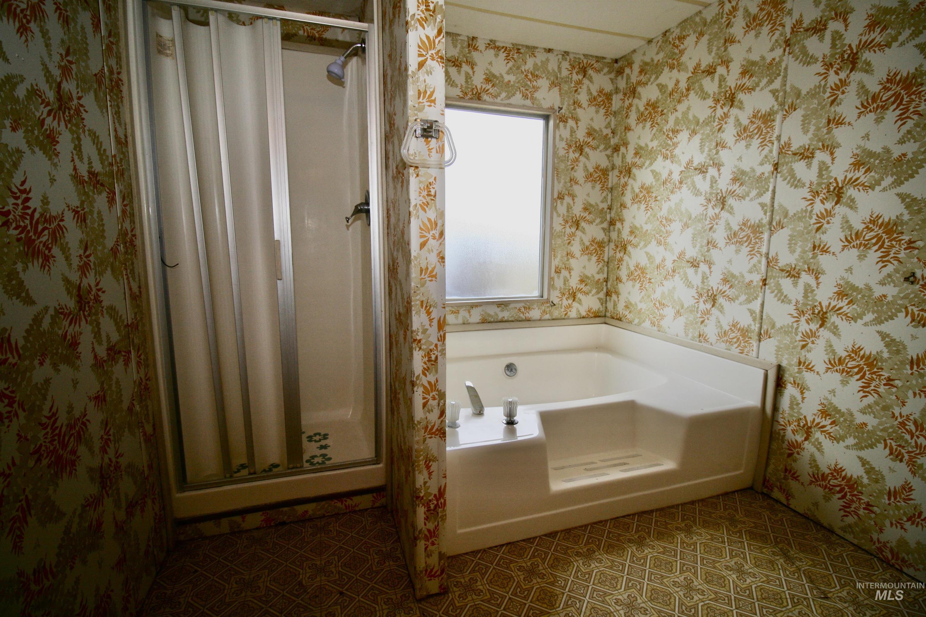 500 Somerville Street Jordan Valley, OR 97910 - Photo 20 of 35 Bathroom featuring wallpapered walls, a bath, a shower stall, and tile patterned flooring