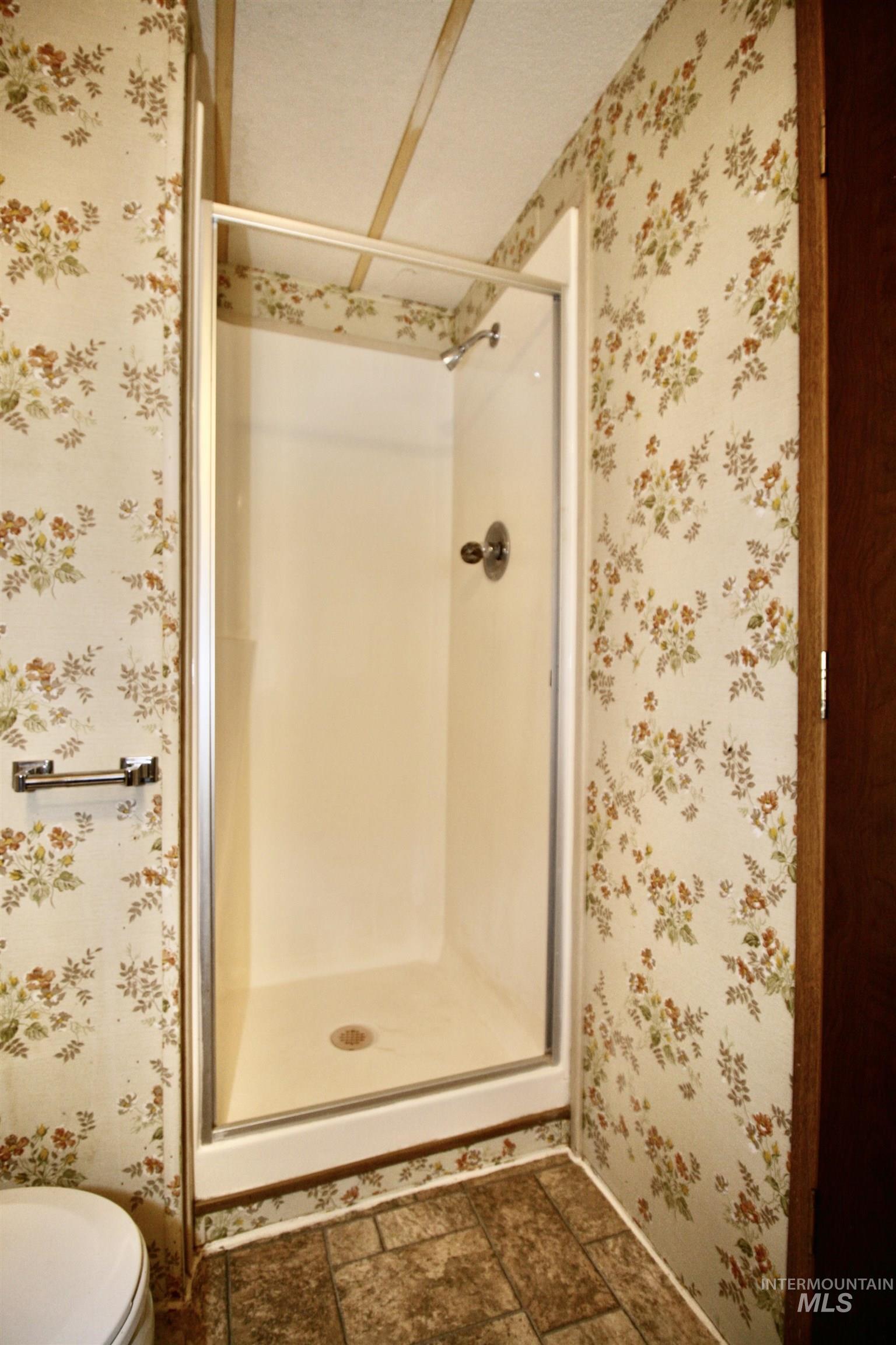 500 Somerville Street Jordan Valley, OR 97910 - Photo 24 of 35 Full bathroom with a stall shower, wallpapered walls, and stone finish flooring