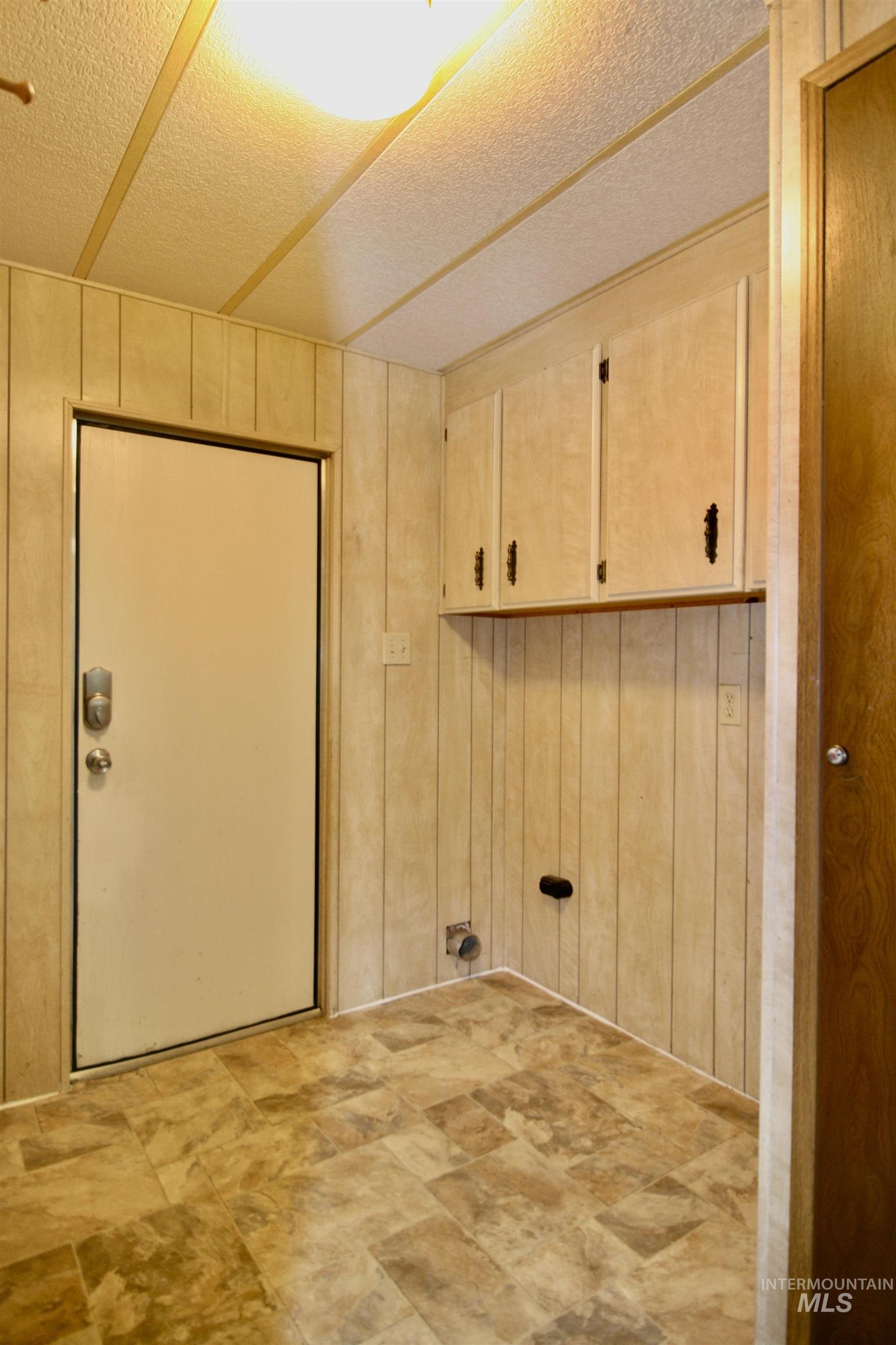 500 Somerville Street Jordan Valley, OR 97910 - Photo 26 of 35 Laundry area with cabinet space, wood walls, and a textured ceiling