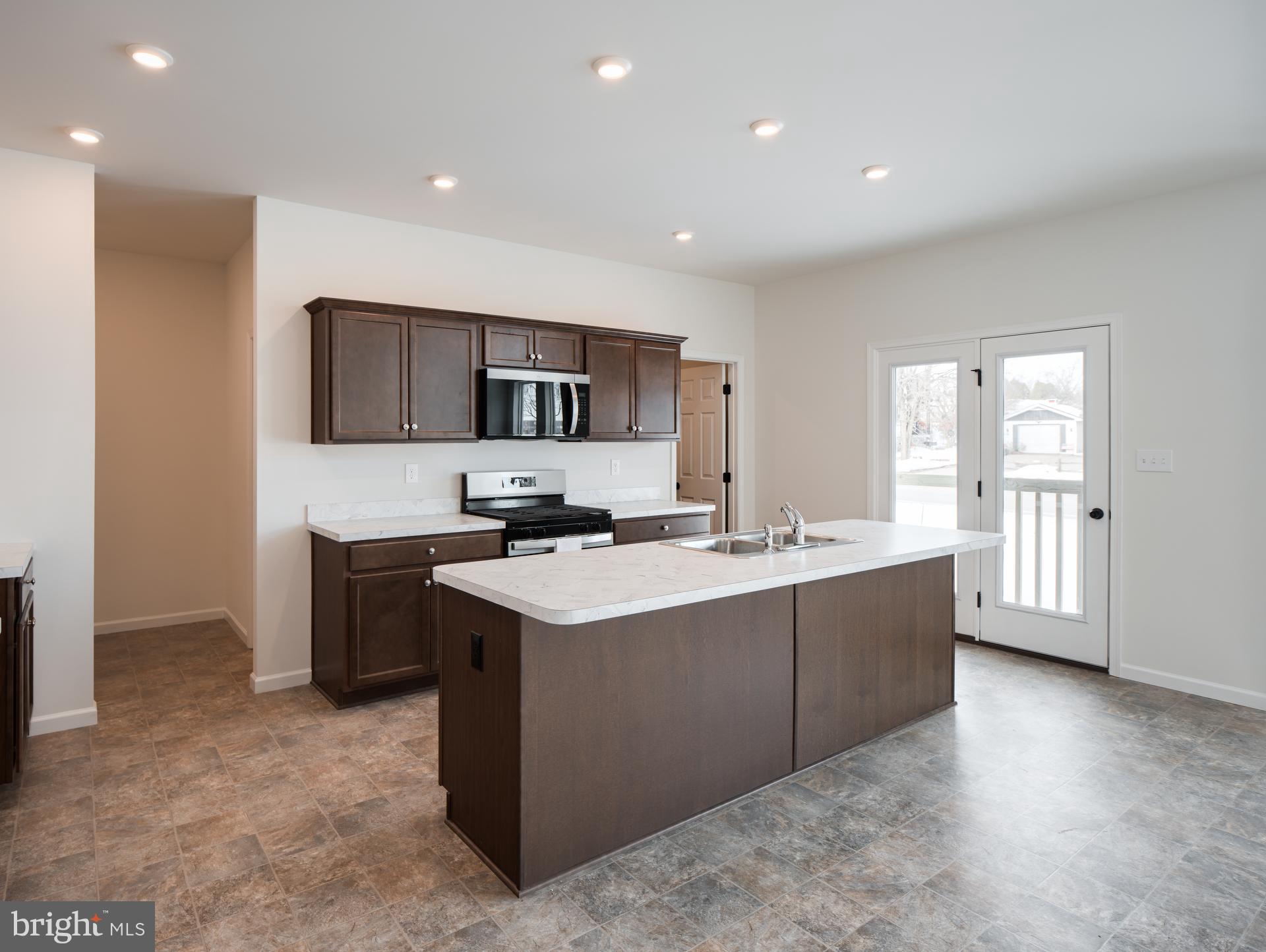 415 Little Walnut Court Windsor, PA 17366 - Photo 30 of 53 a large kitchen with kitchen island a sink dishwasher a stove and a refrigerator with wooden floor