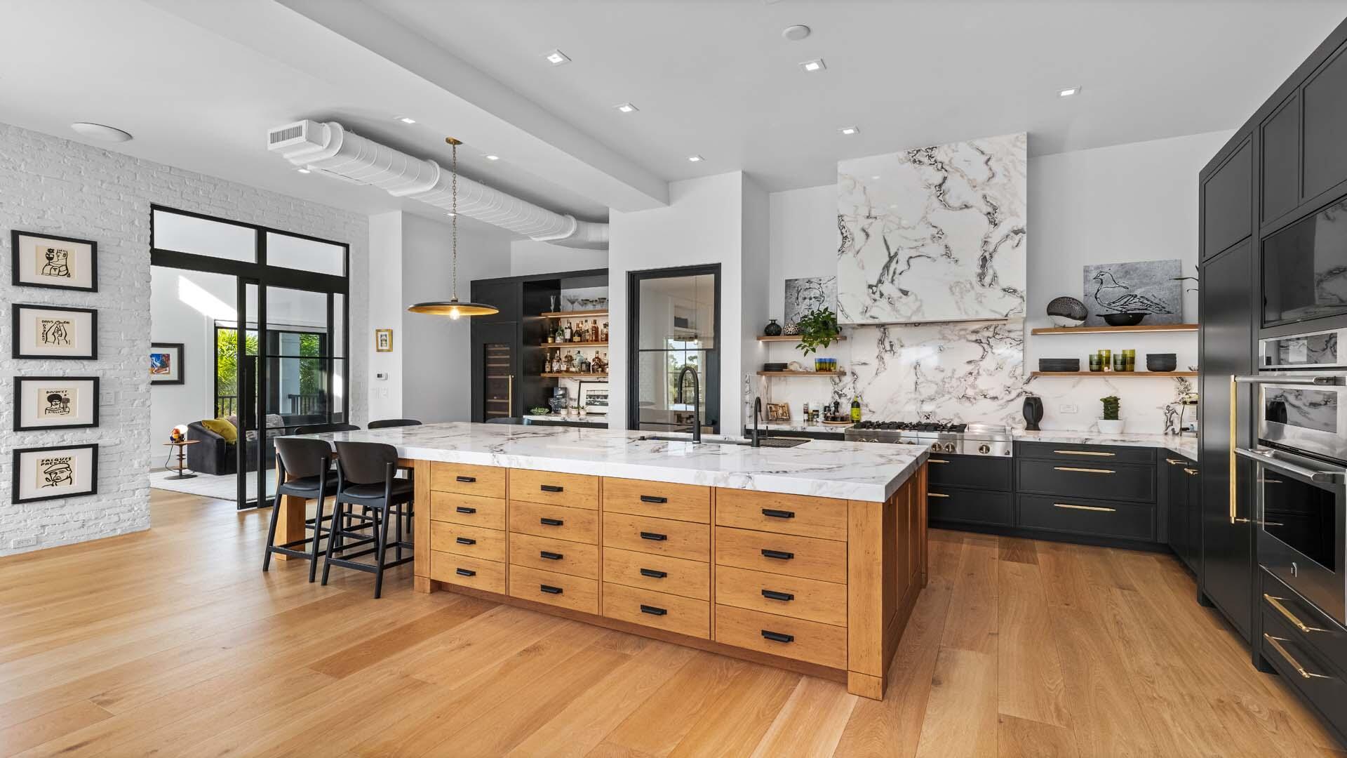 230 George Bush Boulevard Delray Beach, FL 33444 - Photo 13 of 51 a kitchen with stainless steel appliances kitchen island granite countertop a stove top oven a sink a dining table and chairs with wooden floor