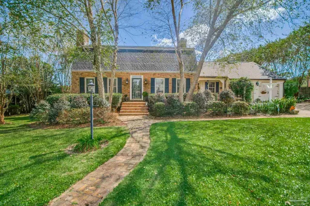 a view of swimming pool with lawn chairs and plants