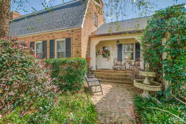a bedroom with a bed a couch and a large window