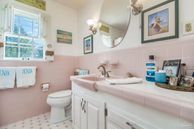 a utility room with stainless steel appliances granite countertop a sink and a stove next to a window