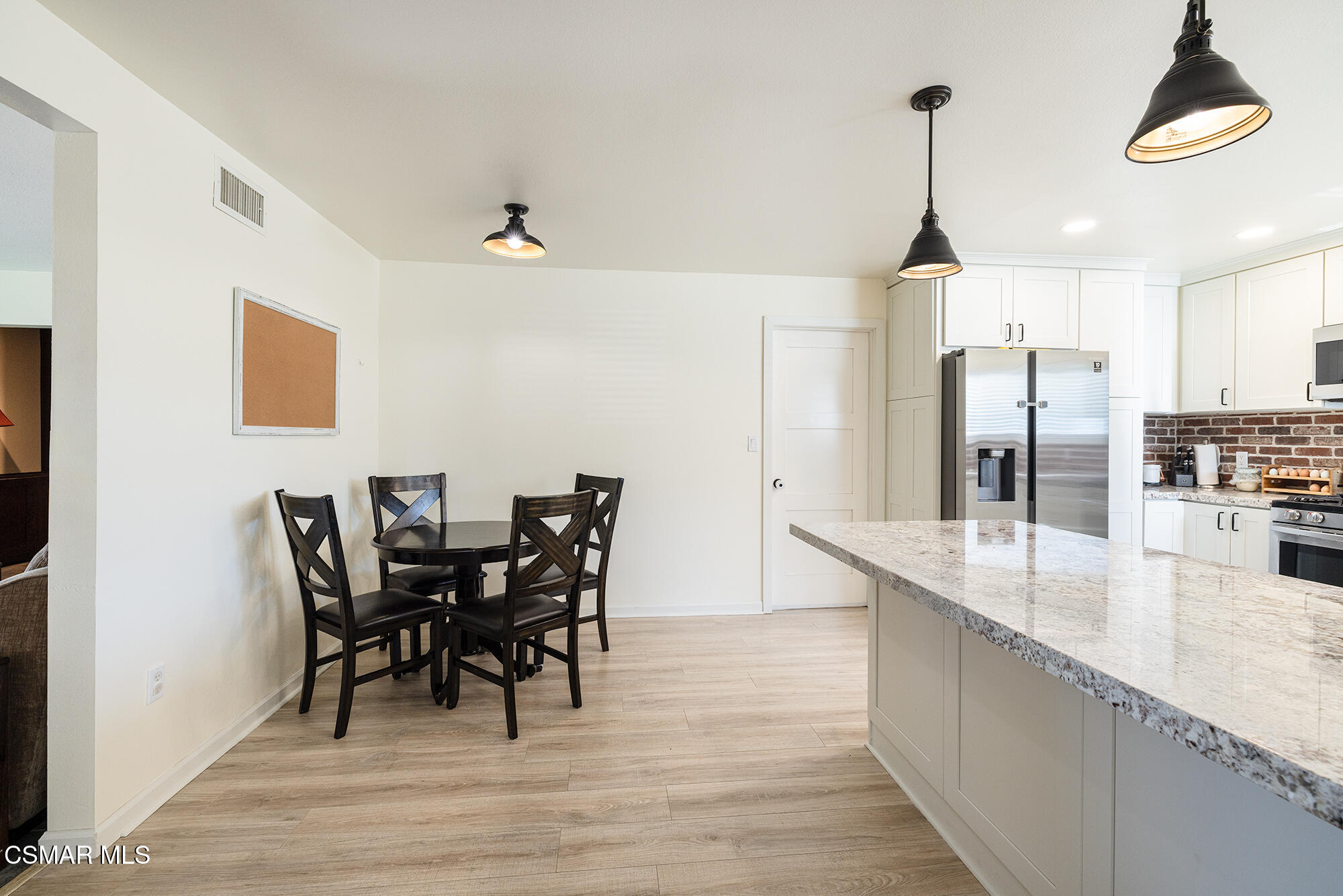 4828 Walnut Avenue Simi Valley, CA 93063 - Photo 9 of 25 a kitchen with stainless steel appliances kitchen island granite countertop a table chairs and a refrigerator