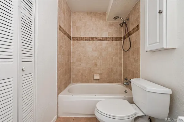a bathroom with a toilet bathtub window and shower