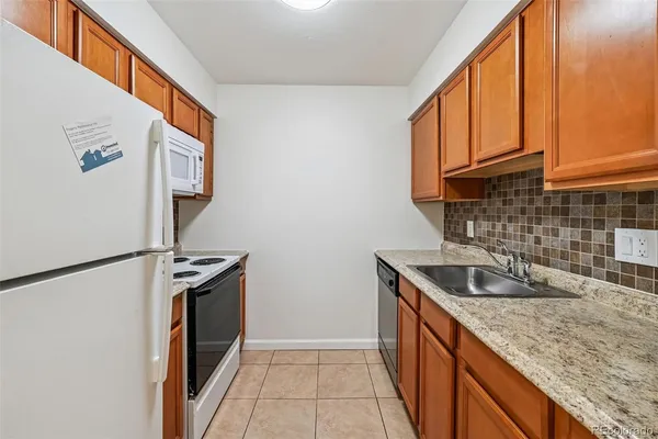 a kitchen with stainless steel appliances granite countertop a sink and a refrigerator