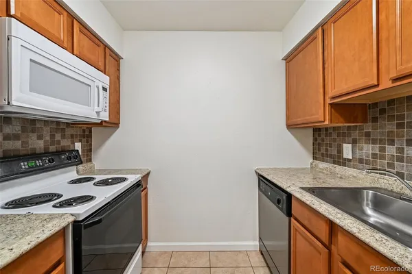 a kitchen with granite countertop a sink stove and cabinets