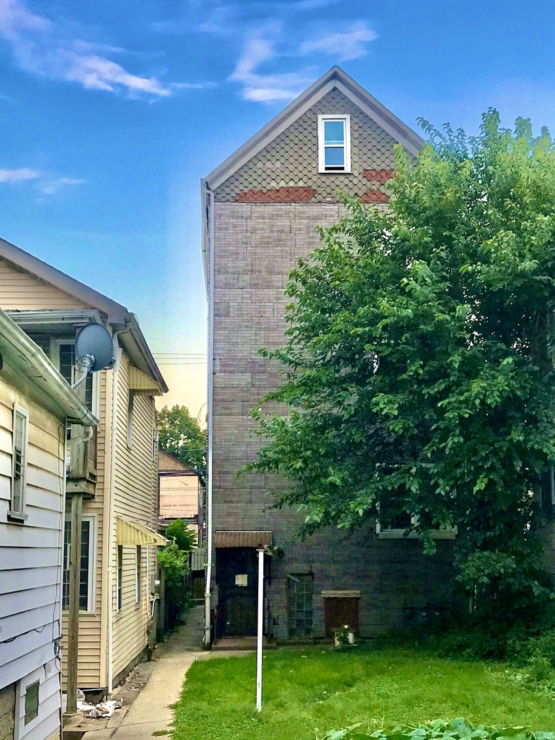 937 West 33rd Place, Unit 3F Chicago, IL 60608 - Photo 1 of 6 a view of a brick house with a yard