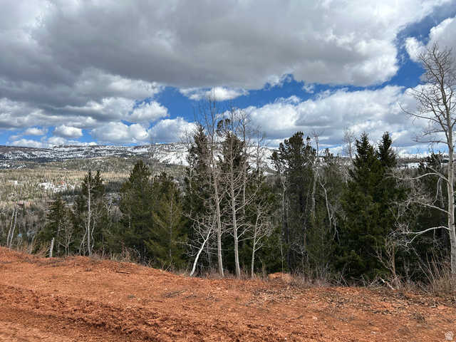 524 West Ski View Drive Brian Head, UT 84719 - Photo 8 of 11 Mountainous terrain featuring a mix of evergreen and deciduous trees, a partially snow-covered distant landscape, and an expansive sky with varied cloud formations