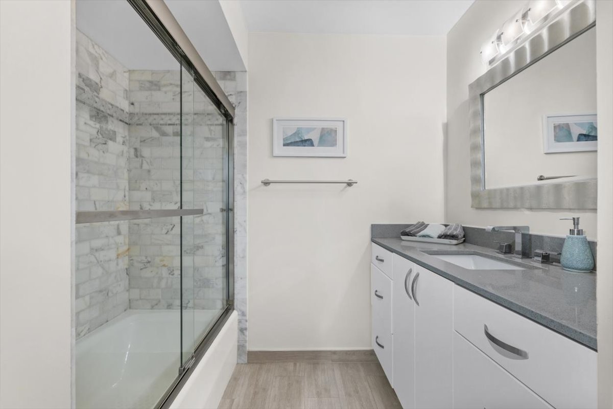 3741 Mission Hills Road, Unit 410 Northbrook, IL 60062 - Photo 21 of 21 a bathroom with a granite countertop sink a mirror and shower