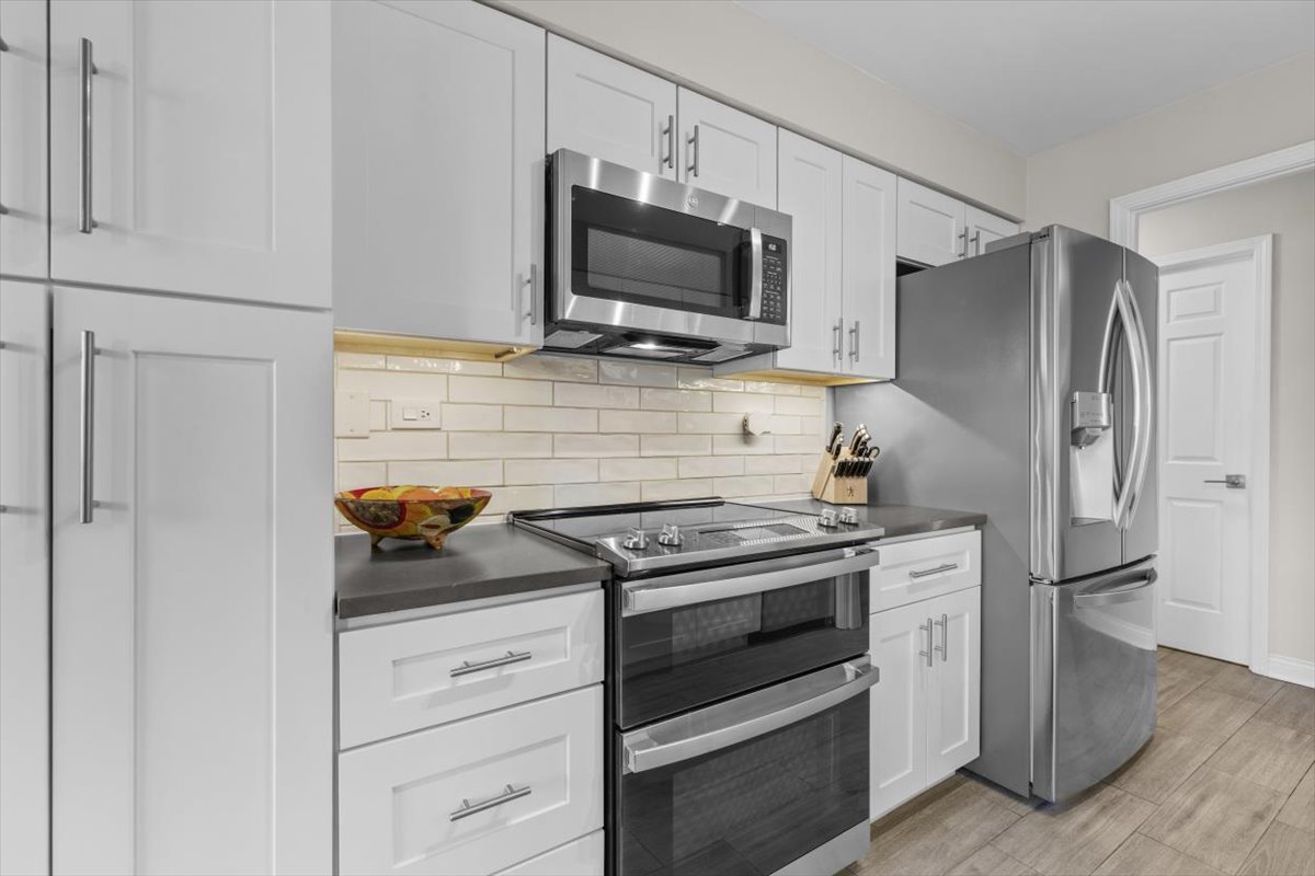 3741 Mission Hills Road, Unit 410 Northbrook, IL 60062 - Photo 6 of 21 a kitchen with white cabinets and stainless steel appliances