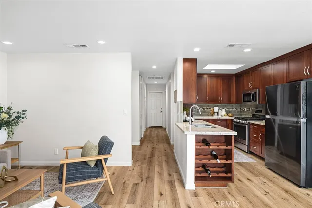 a kitchen with stainless steel appliances kitchen island granite countertop a refrigerator and a stove top oven