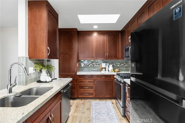 a kitchen with granite countertop a sink stove and cabinets