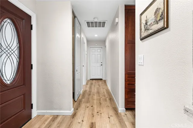 a view of a hallway with wooden floor and entryway