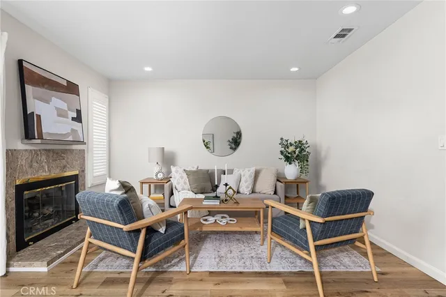 a living room with furniture a fireplace and a potted plant