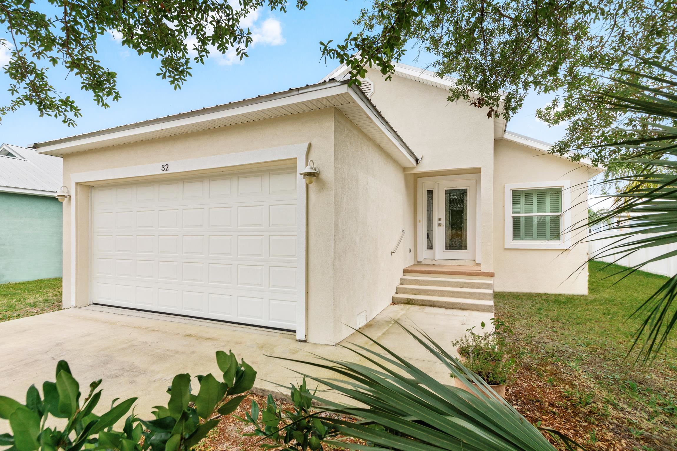 a view of a white house with wooden fence