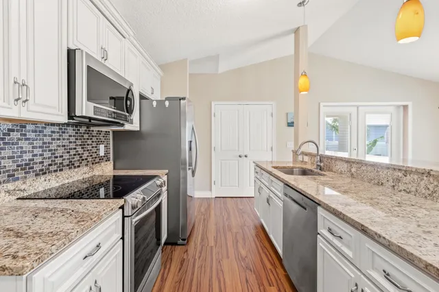 a kitchen with stainless steel appliances granite countertop a sink stove and refrigerator