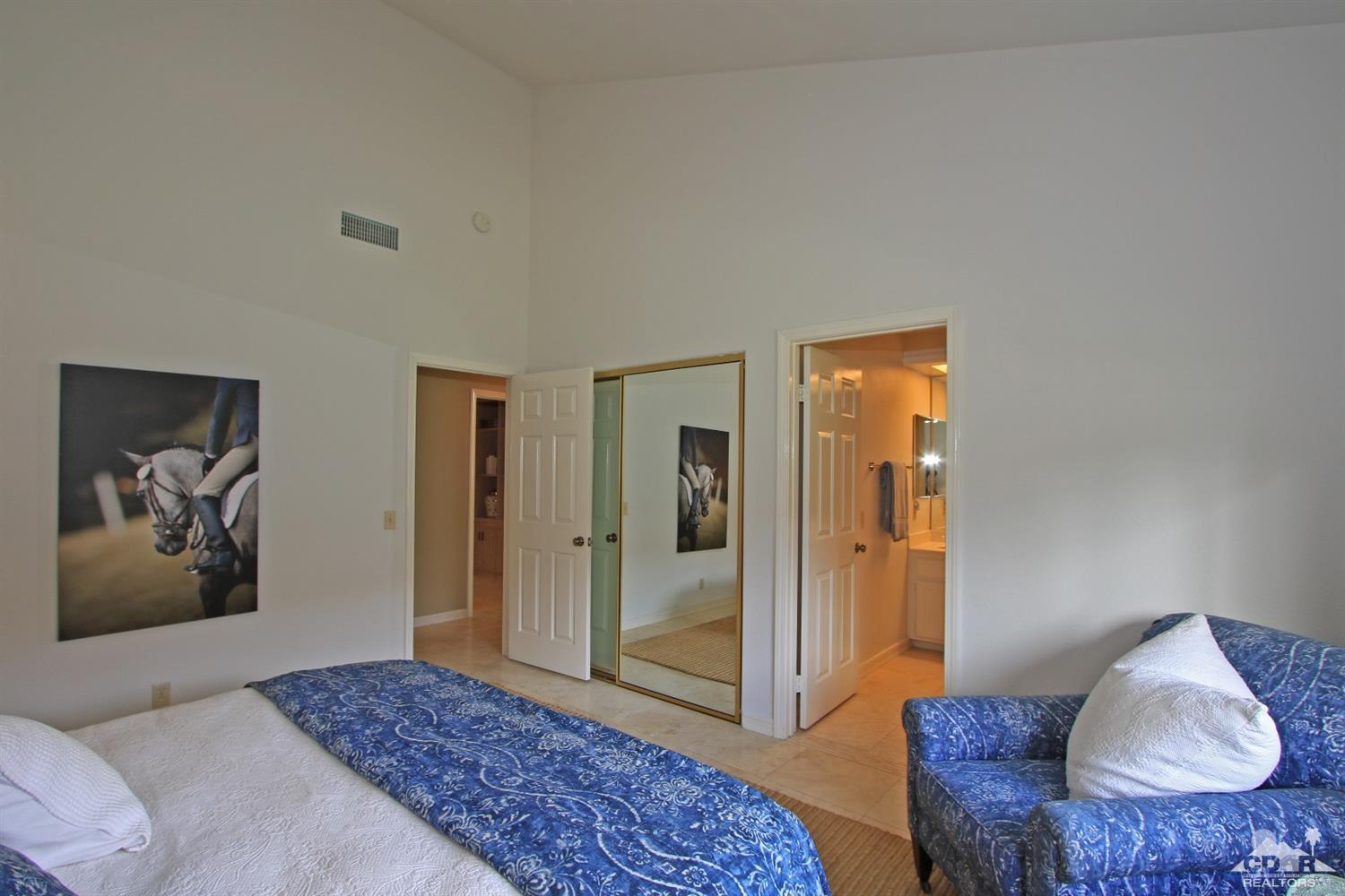 198 Ranch View Circle Palm Desert, CA 92211 - Photo 36 of 54 a bedroom with a bed and bathroom with mirror