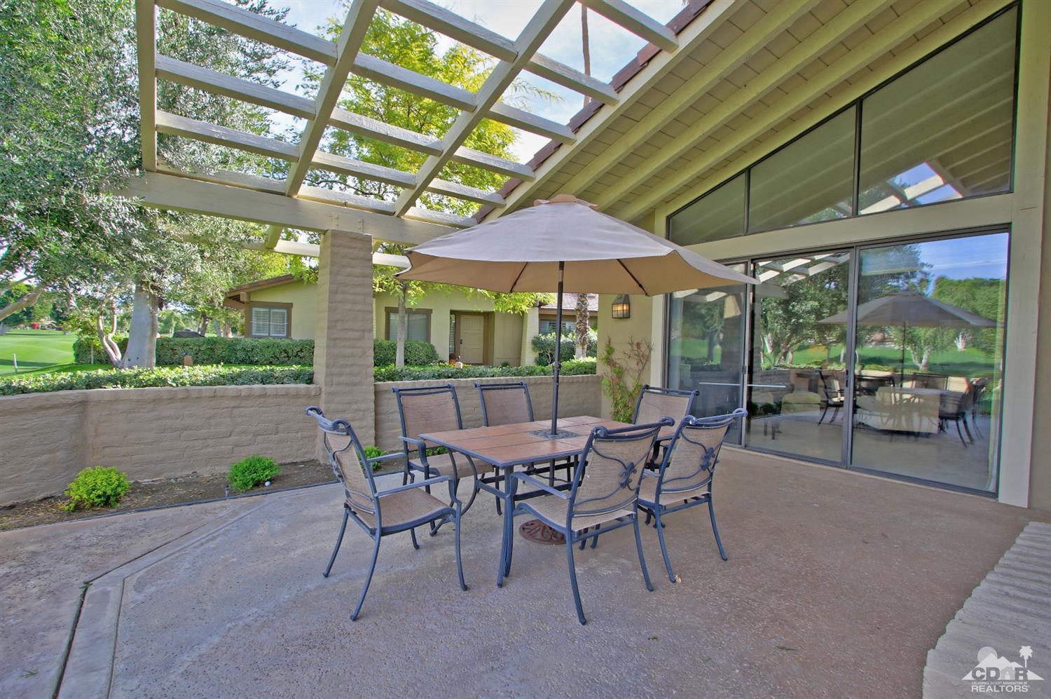 198 Ranch View Circle Palm Desert, CA 92211 - Photo 44 of 54 a view of a patio with a table and chairs under an umbrella