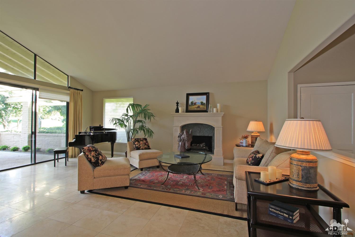198 Ranch View Circle Palm Desert, CA 92211 - Photo 6 of 54 a living room with furniture a fireplace and a floor to ceiling window