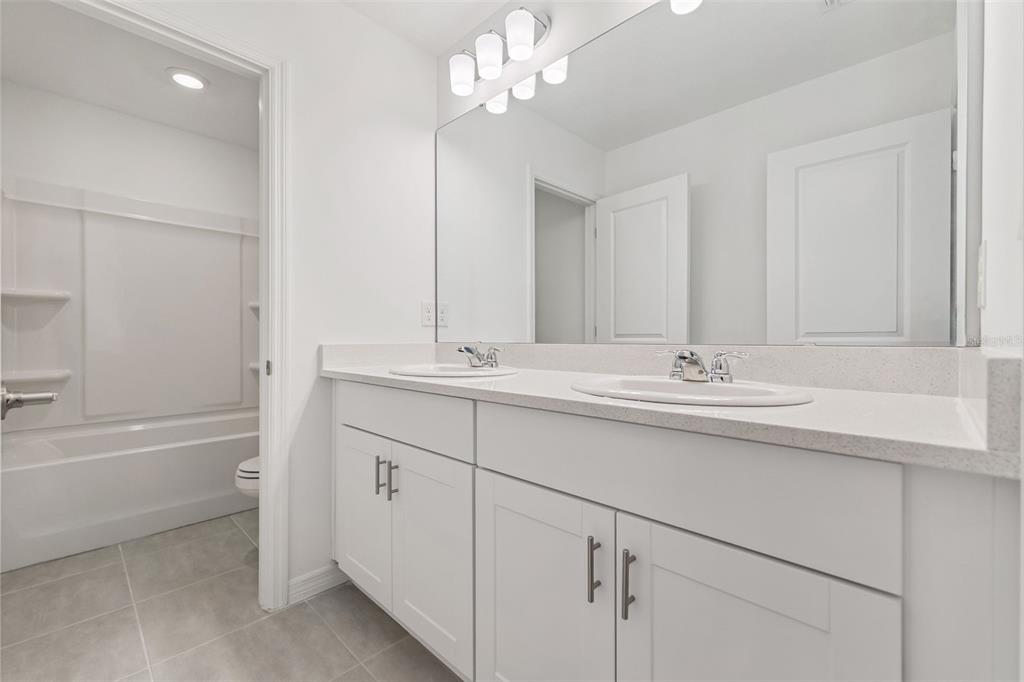 188 Jones Fish Camp Road Edgewater, FL 32141 - Photo 19 of 34 a bathroom with a sink a mirror and a bathtub with shower