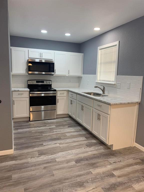 514 Oak Street Sanger, TX 76266 - Photo 1 of 1 a kitchen with stainless steel appliances granite countertop a stove a sink and a microwave