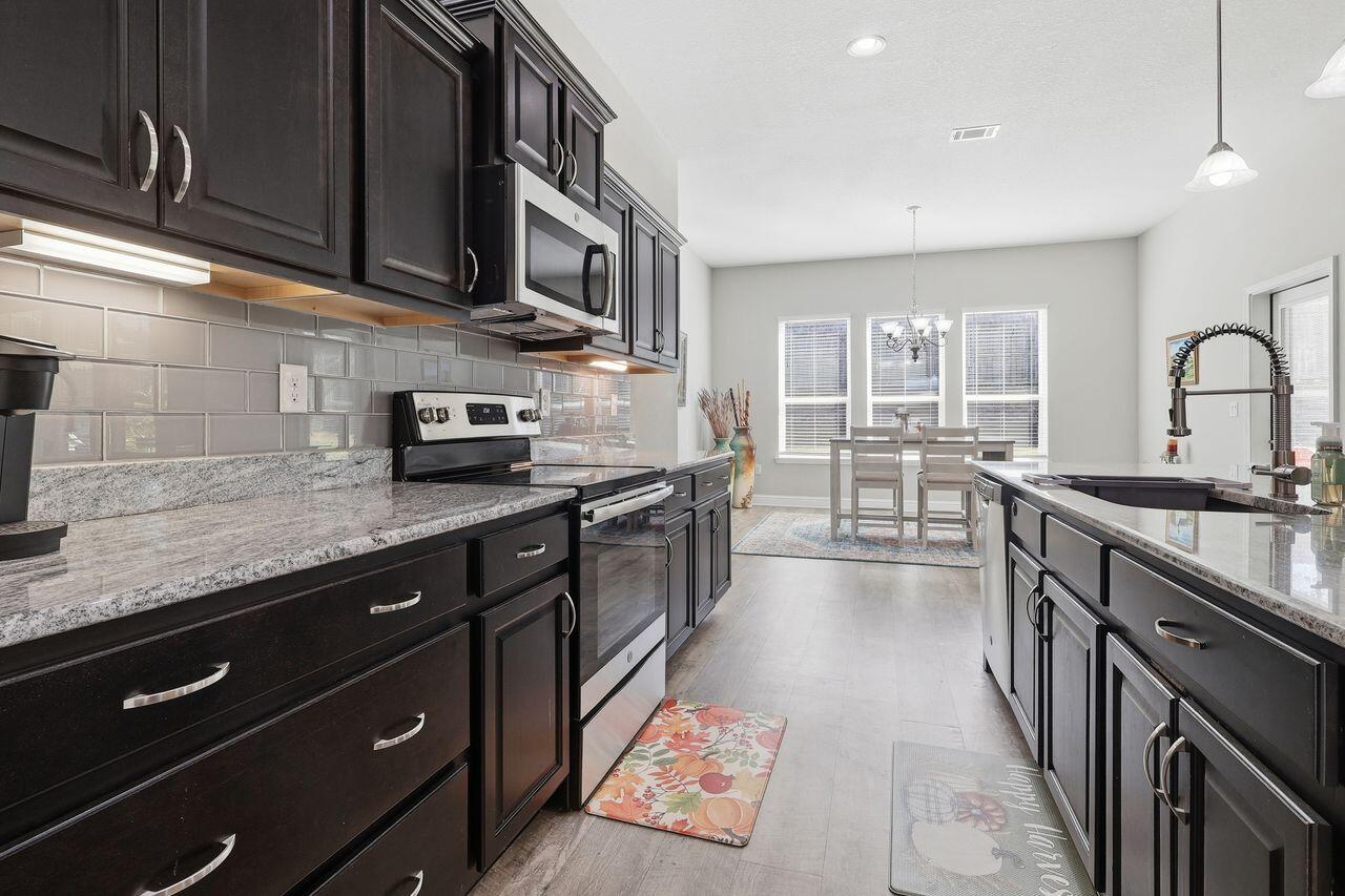 3025 Crown Creek Circle Crestview, FL 32539 - Photo 12 of 46 a large kitchen with stainless steel appliances wooden cabinets a stove and a sink