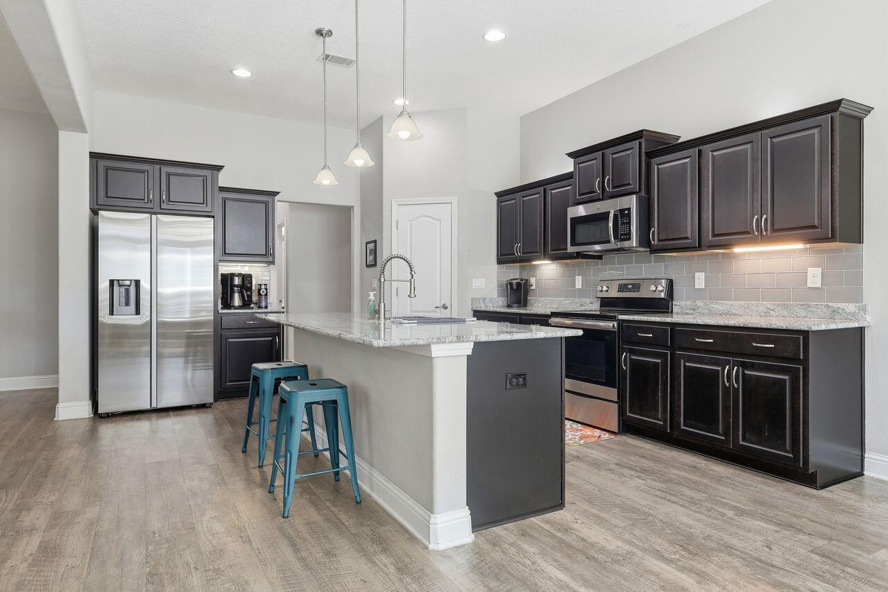 3025 Crown Creek Circle Crestview, FL 32539 - Photo 15 of 46 a kitchen with stainless steel appliances kitchen island granite countertop a stove a sink and a refrigerator